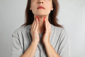 Mature woman doing thyroid self examination
