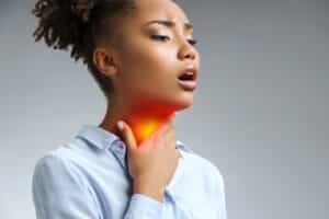 Woman holding her inflamed throat.